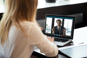 Back,View,Of,Female,Employee,Talk,On,Video,Call,With Back view of female employee talk on video call with male colleague or business partner, woman worker communicate online speak on Webcam, have web conference with coworker from home office